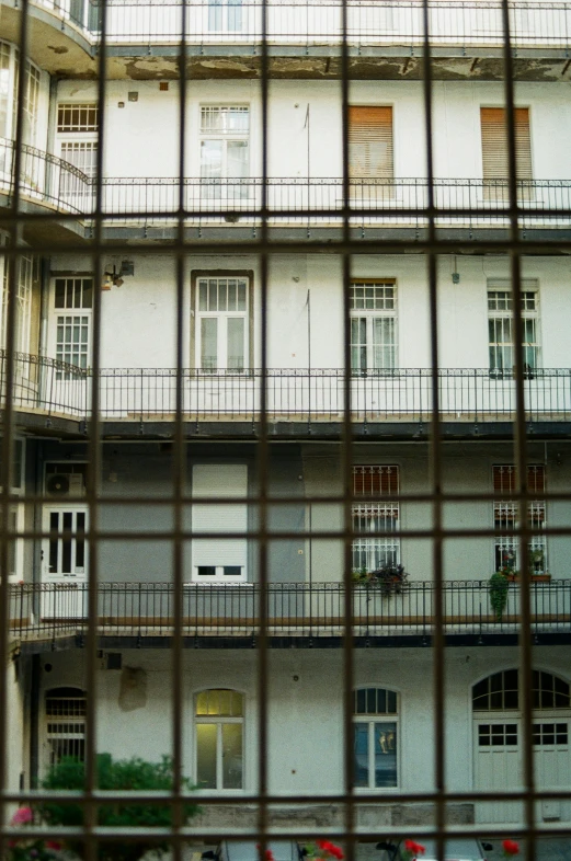 looking through bars to windows and an apartment building