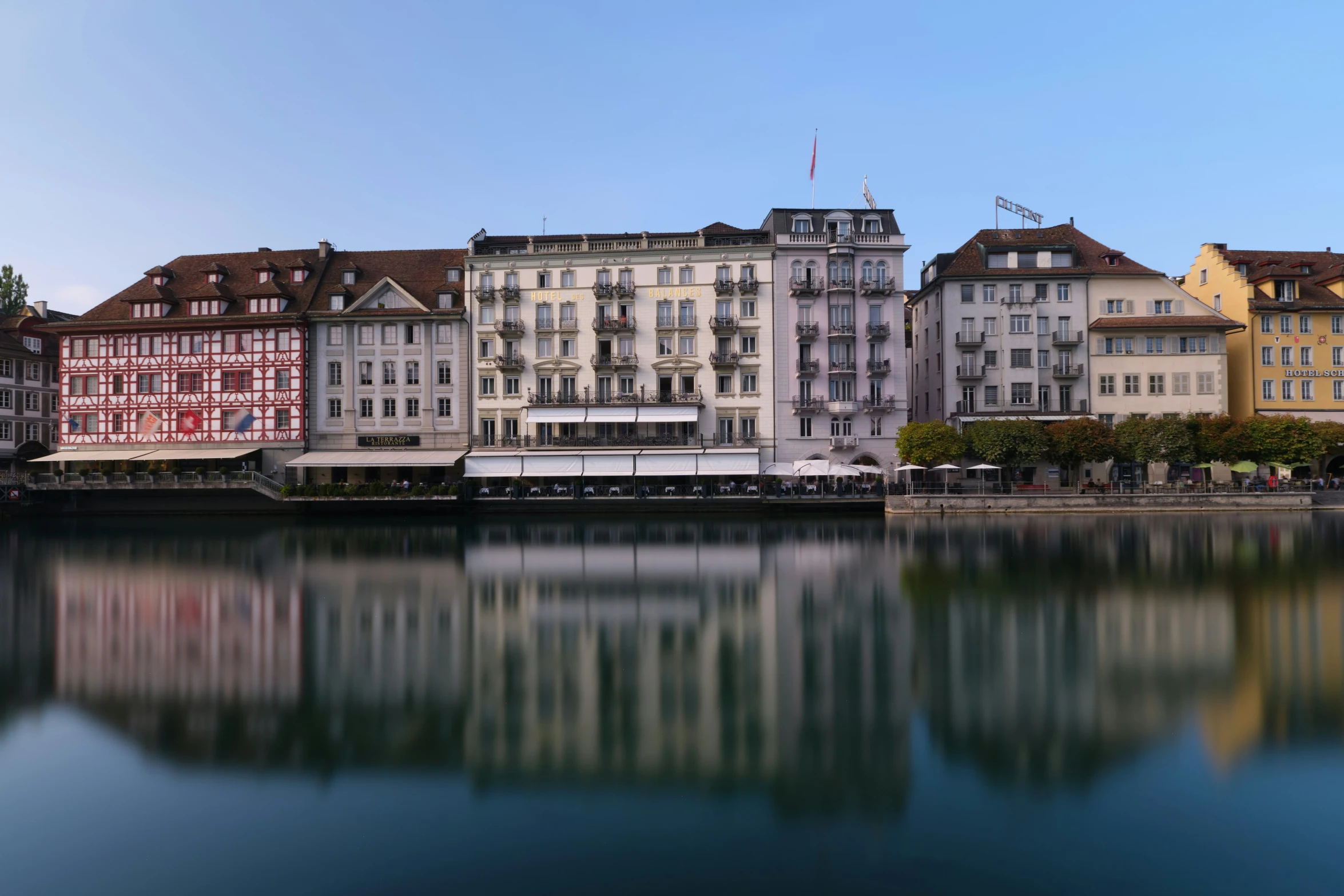 the buildings are next to the water and reflected in the water