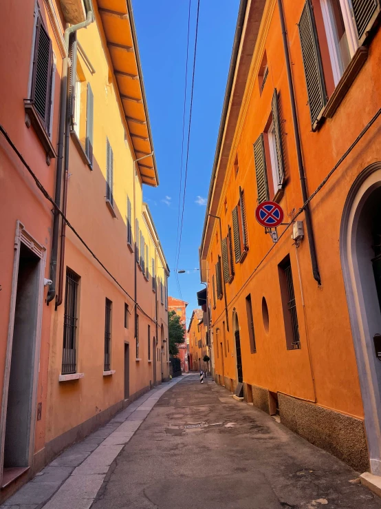 a city street with small buildings that have yellow walls and red shutters