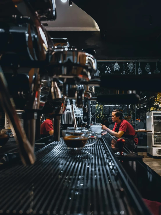two workers are working on some machines in a shop