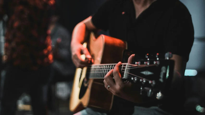 someone playing a guitar in front of a microphone