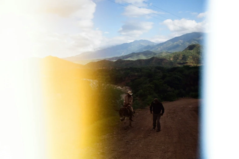 a man that is standing on the side of a dirt road