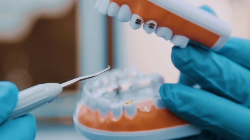 a dentist is holding an orange tooth brush