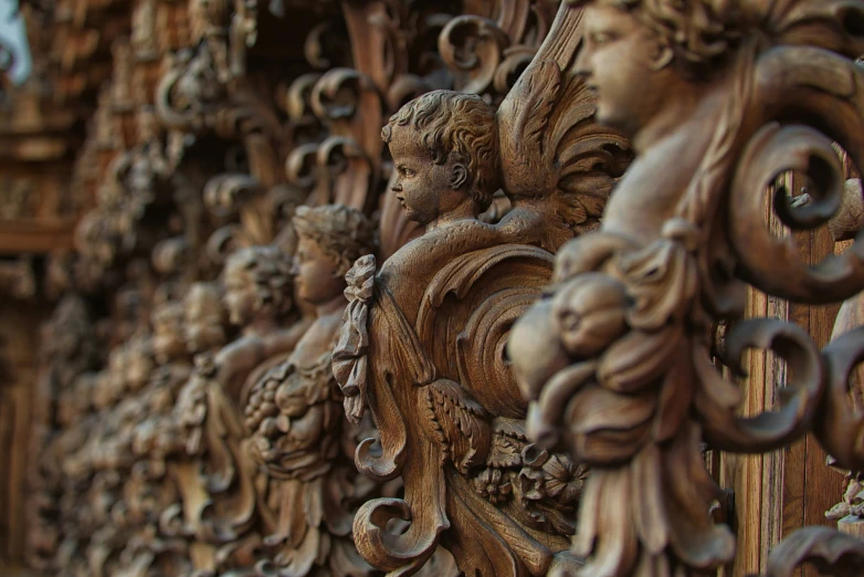 sculptures sitting in front of a building covered in wooden carvings