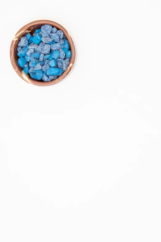 a blue bowl of candy on a white background
