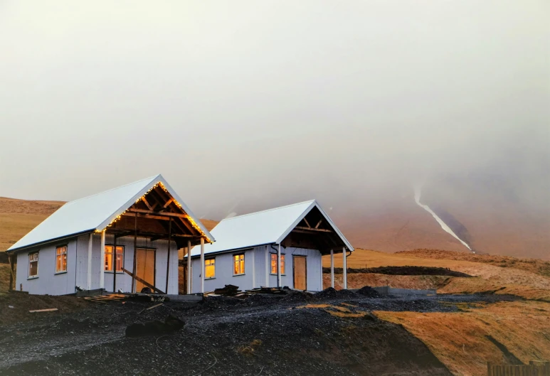 two building on a cliff with snow on the ground