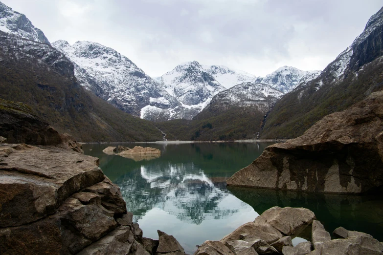 a lake with rocks and mountains around it