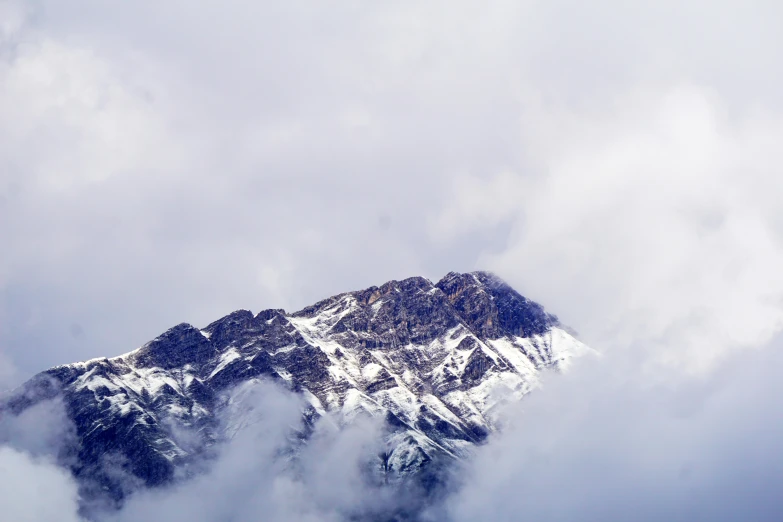 a snowy mountain covered in clouds and snow