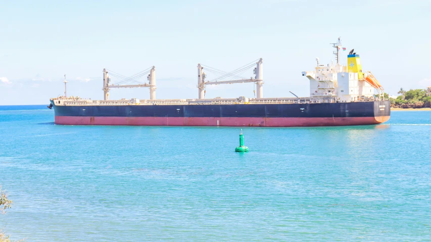 a large ship traveling down a river next to a shore