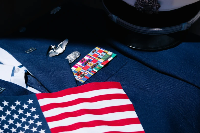 some assorted pins and tie clips lay on a flag shirt