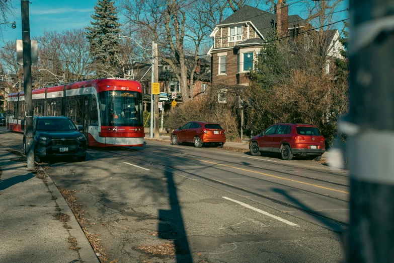 a red and white transit bus drives along a city street