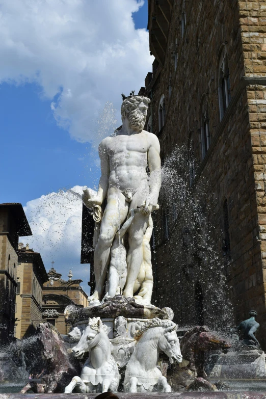 a fountain with white statues and a statue of a boy