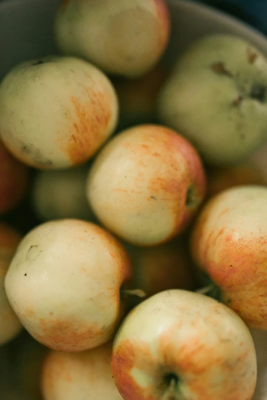 a bowl filled with ripe green and yellow apples