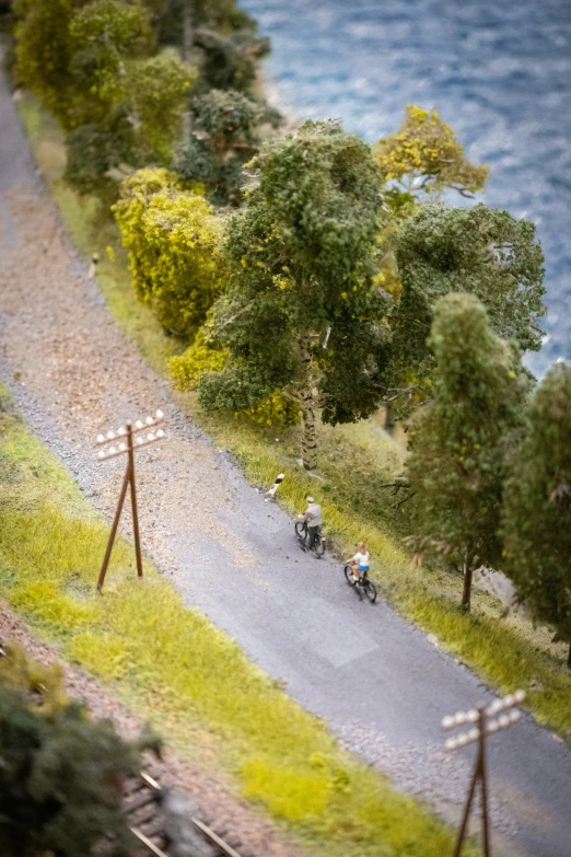 bikers are riding down a steep paved trail