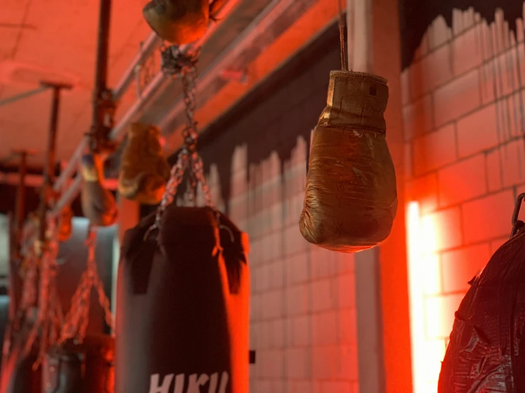 two boxing gloves hanging in a red light