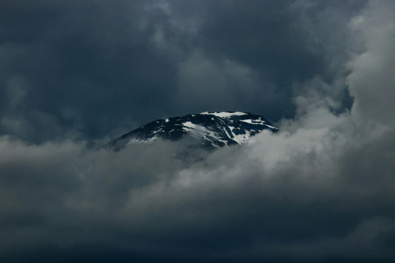 a snowy peak peeking out through storm clouds