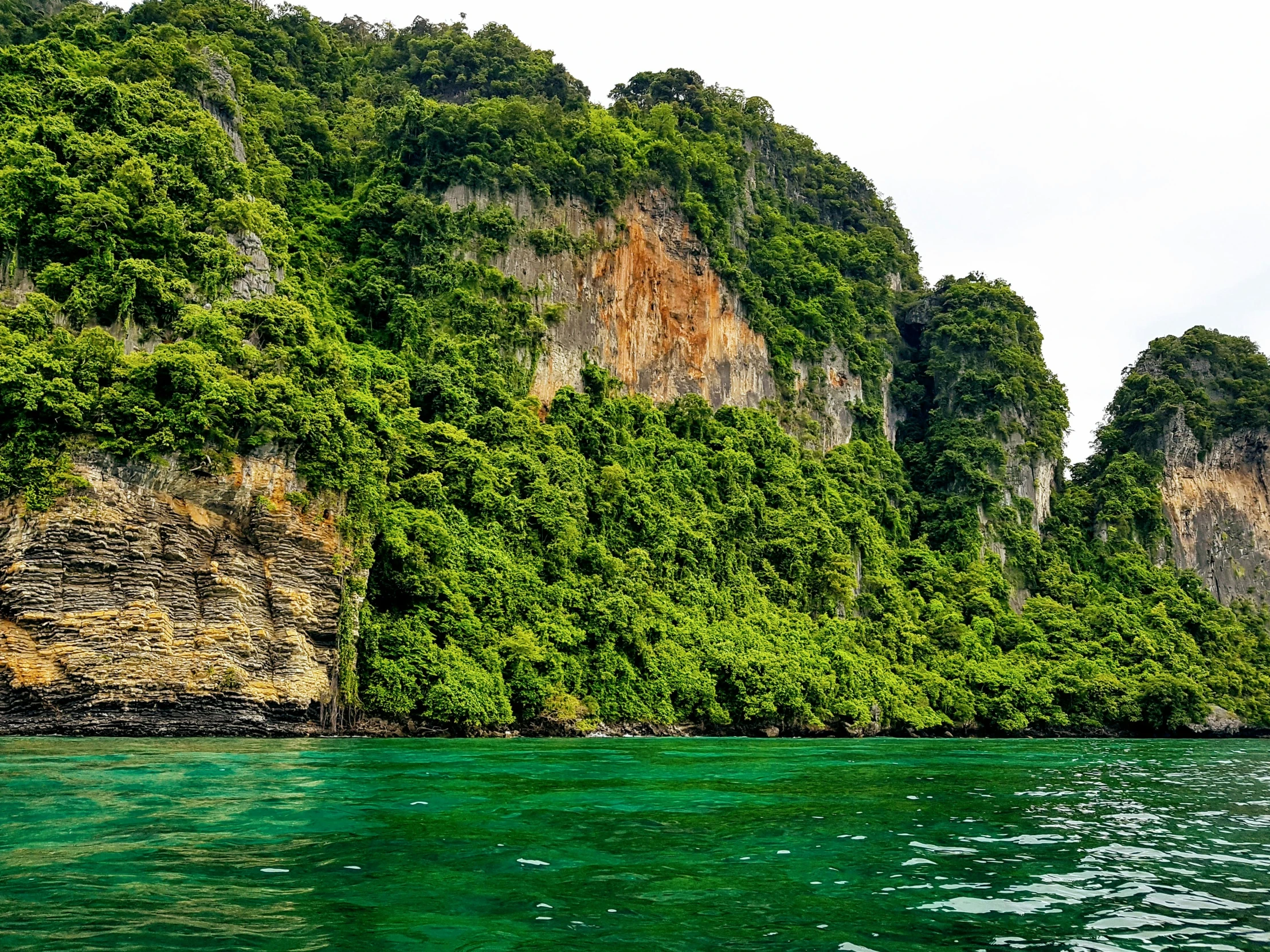 some green water and two large cliffs in the background