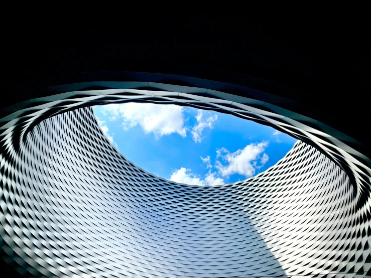 the sky is blue and white, and looking up into the building