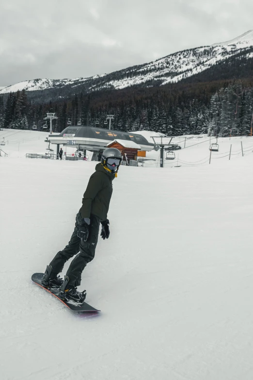 a person riding a snowboard down the side of a snow covered slope