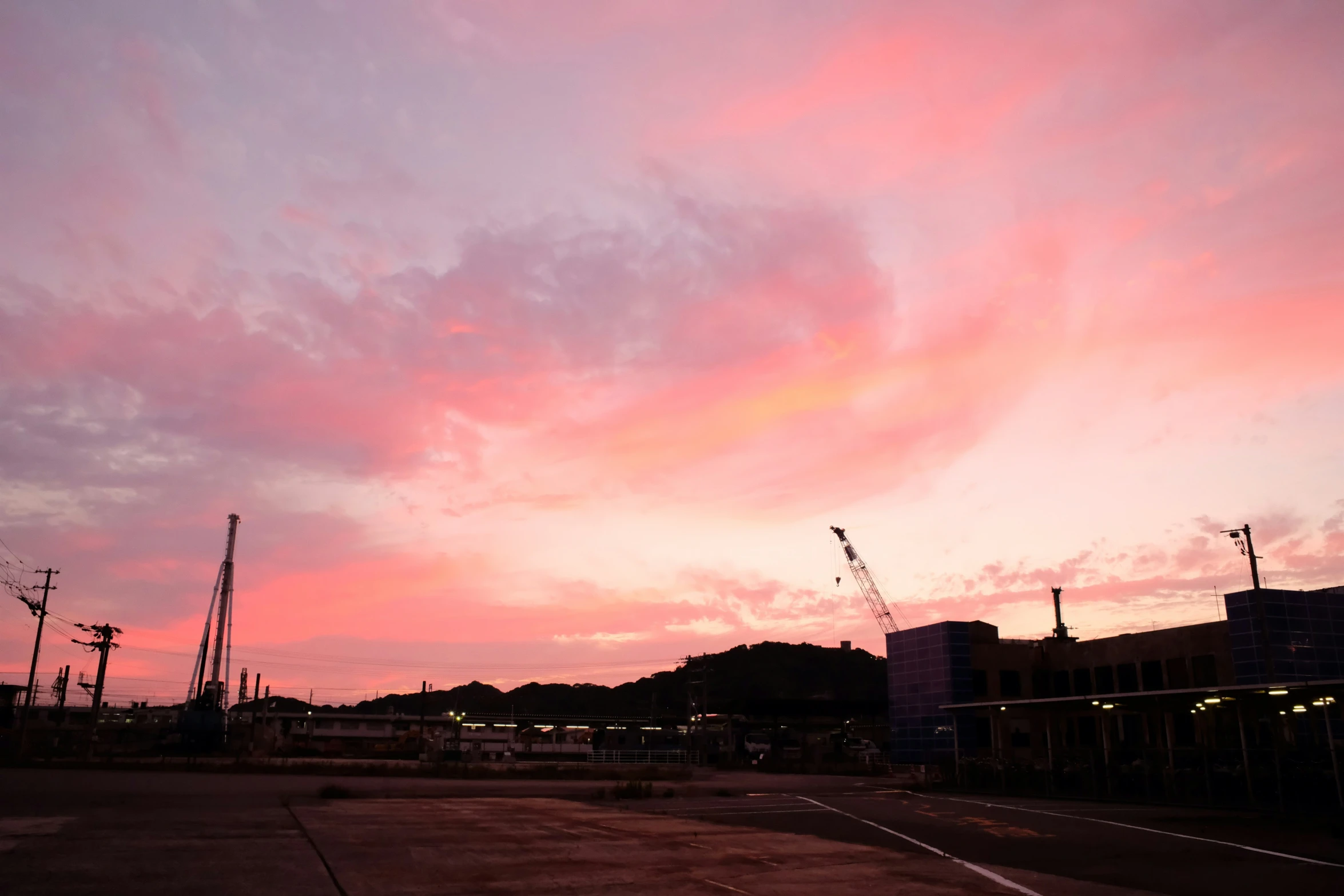 a large building is in the distance, with a big pink sky