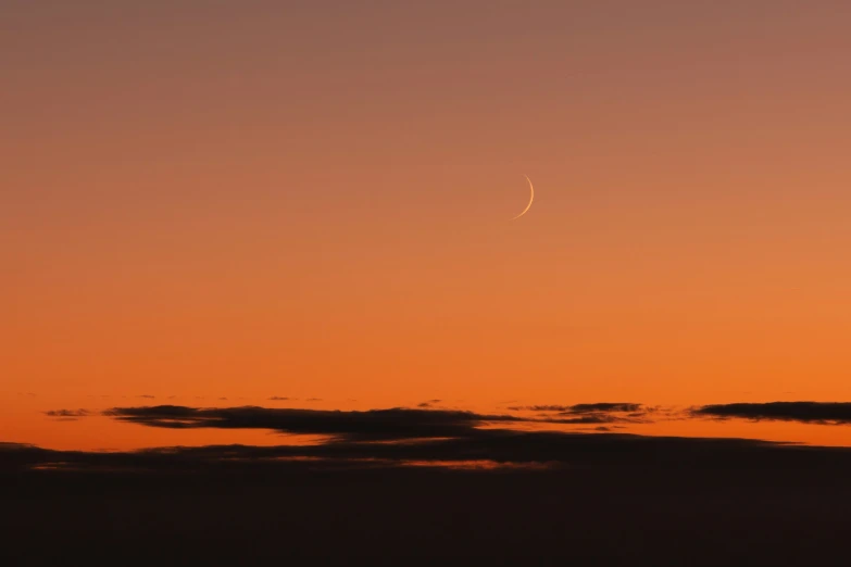 an airplane is flying in the sky at sunset