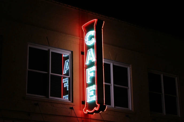 a neon lit sign on the side of a building