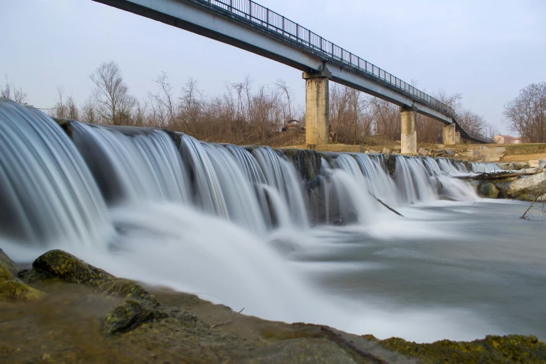 a big bridge spans over the waterfall