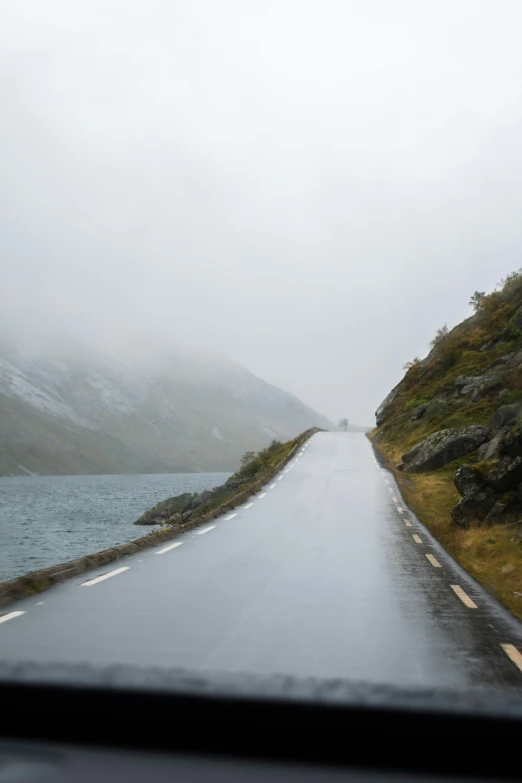 a rain soaked road sitting next to the ocean