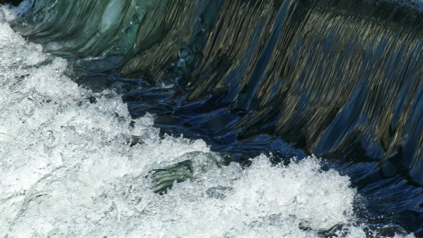 water rushes over the edge of a dam