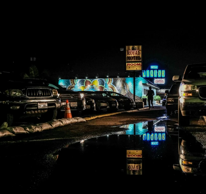 a gas station at night with lights on and several cars parked