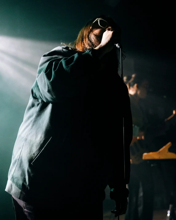 a man in glasses holding a microphone on stage