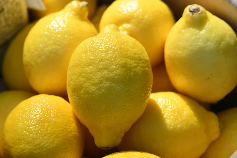 the fresh lemons are arranged together in a basket