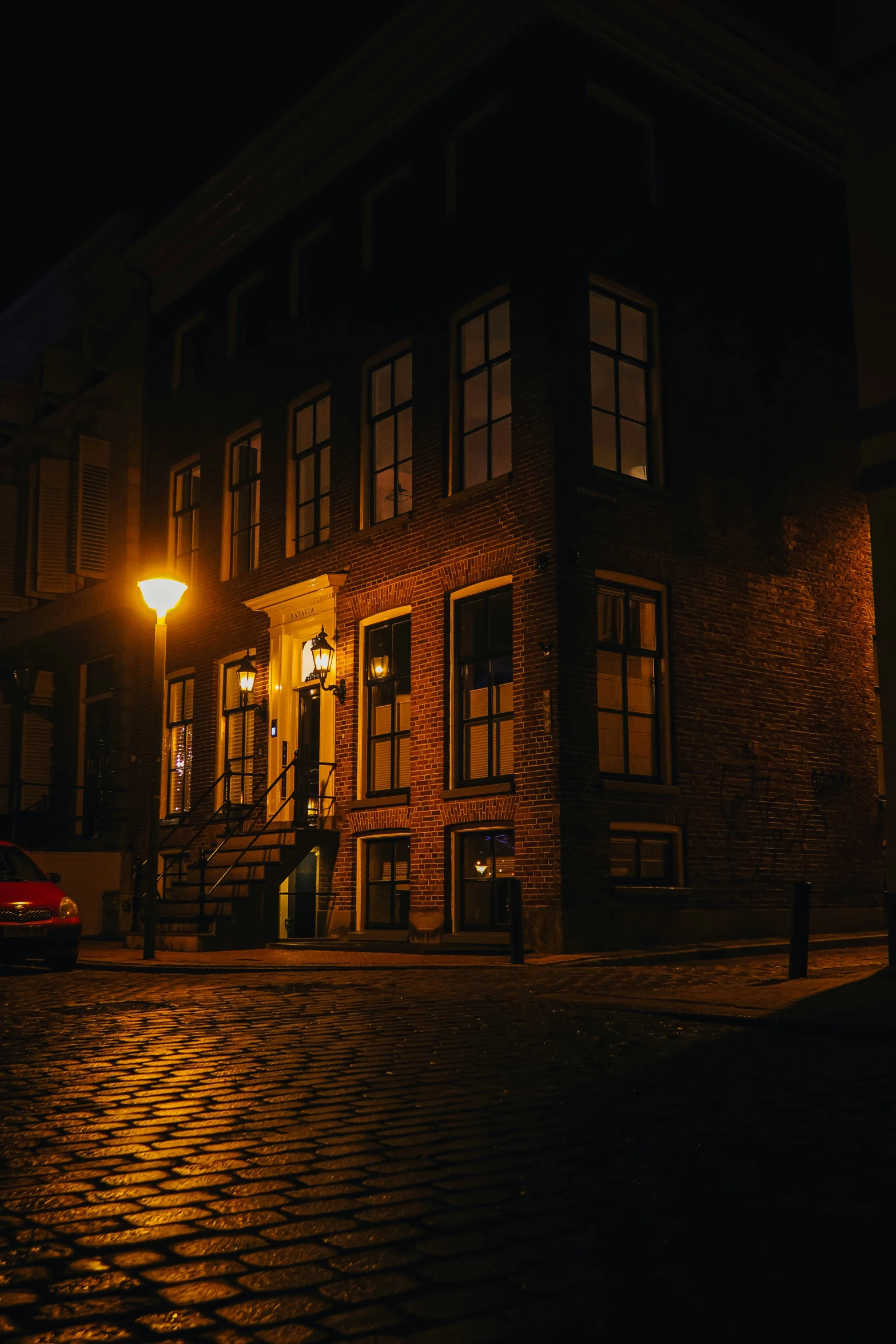 the lights of street lamps shine on the brick building