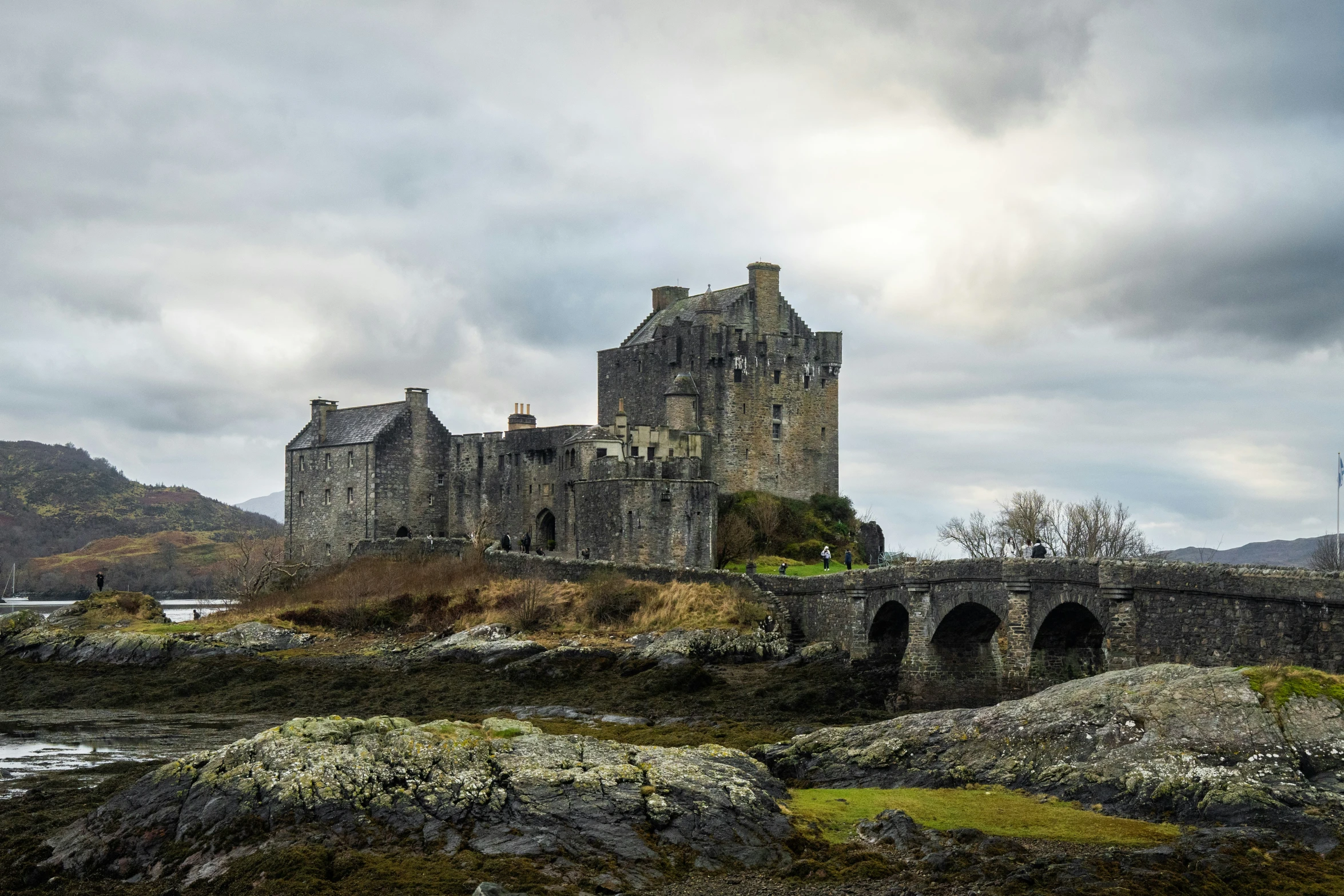 an old castle is perched above some rocky terrain