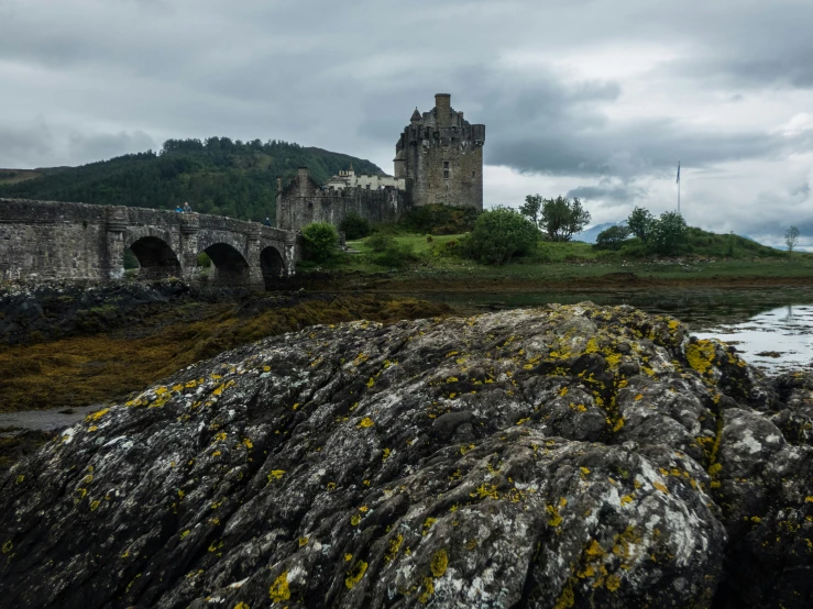 a stone bridge and a castle in the background