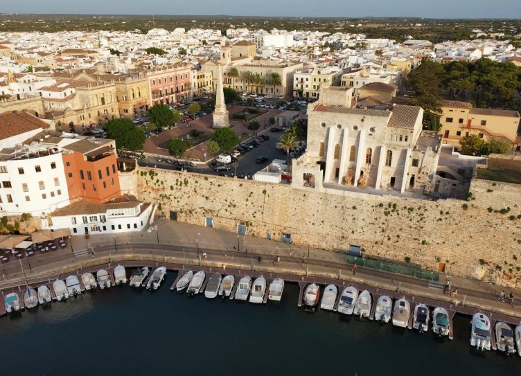 a group of boats docked in the water next to a wall