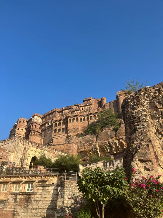 an old stone castle building stands on top of the mountain