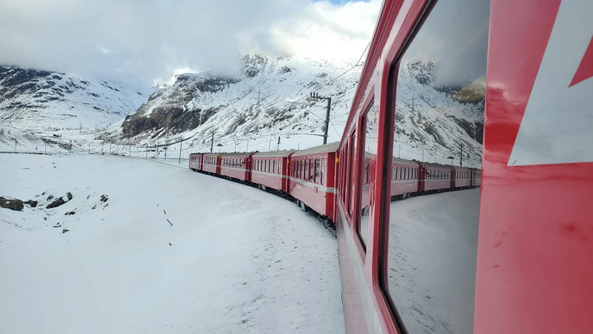 a train traveling through the middle of a snow covered mountains