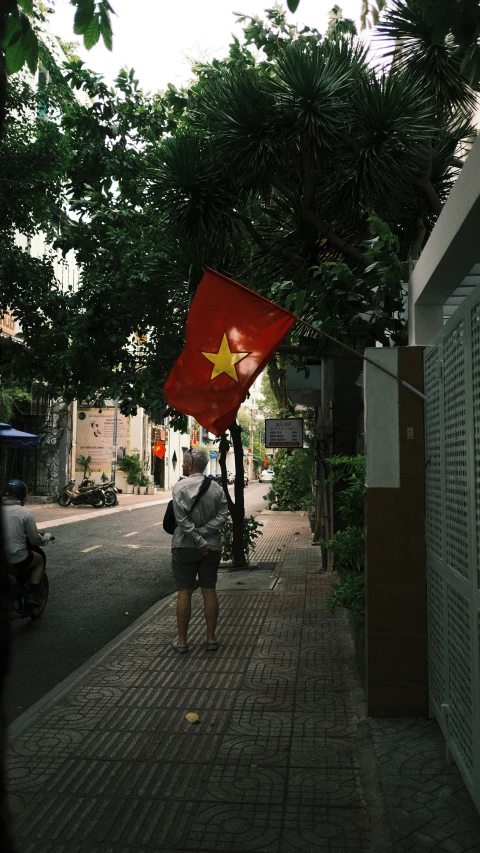 a person holding an red flag and a black bag walking