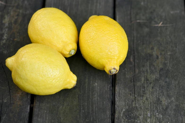 three lemons on a table next to each other