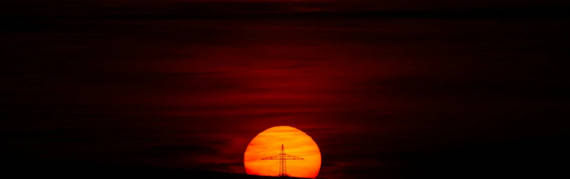 the sun is behind the dark background of a surfboard