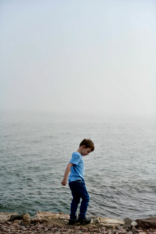 a  standing next to the ocean with rocks