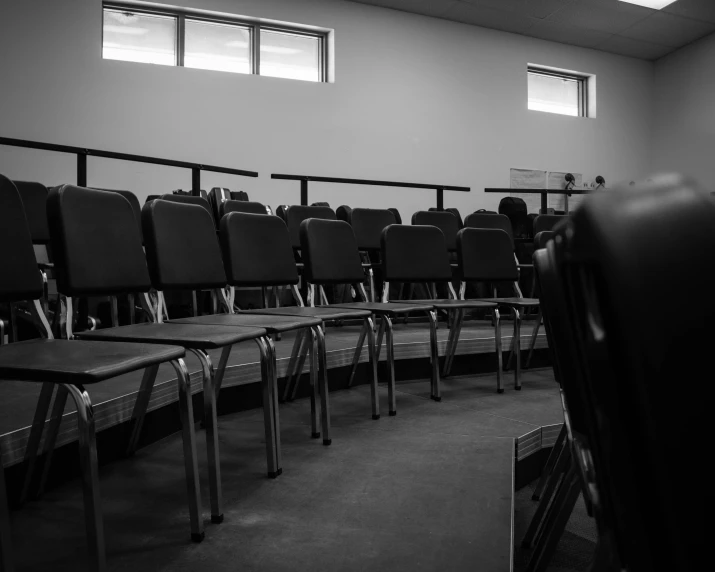 several empty chairs in a large room with a ceiling