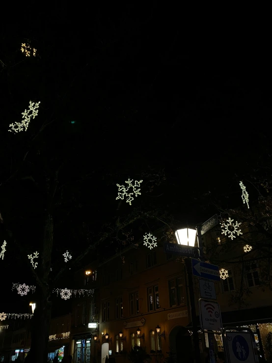 some lights are hanging on a building during the night