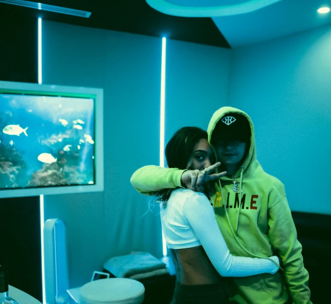 a man and woman emcing near a fish tank