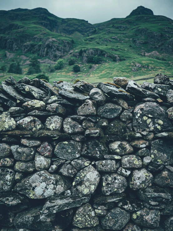 the view of the mountains is seen from behind a rock wall