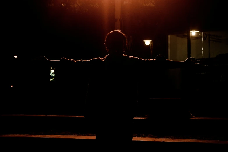 the man is standing outside at night in front of his street light