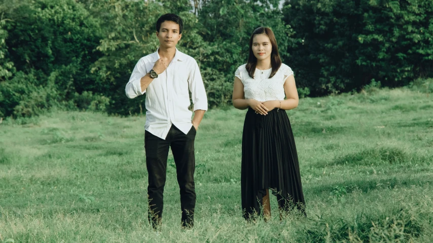 a man and a woman standing in a grassy field together