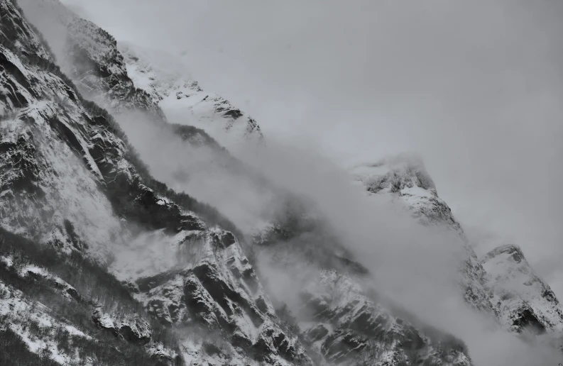 snow covered mountain tops and cloudy skies