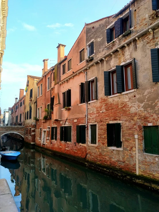 narrow river with buildings on the side and a boat parked near